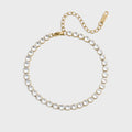 Gold bracelet with clear gemstones on a light gray background