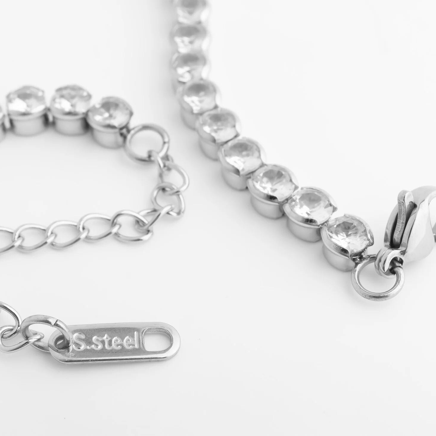 Silver bracelet with clear gemstones on a white background
