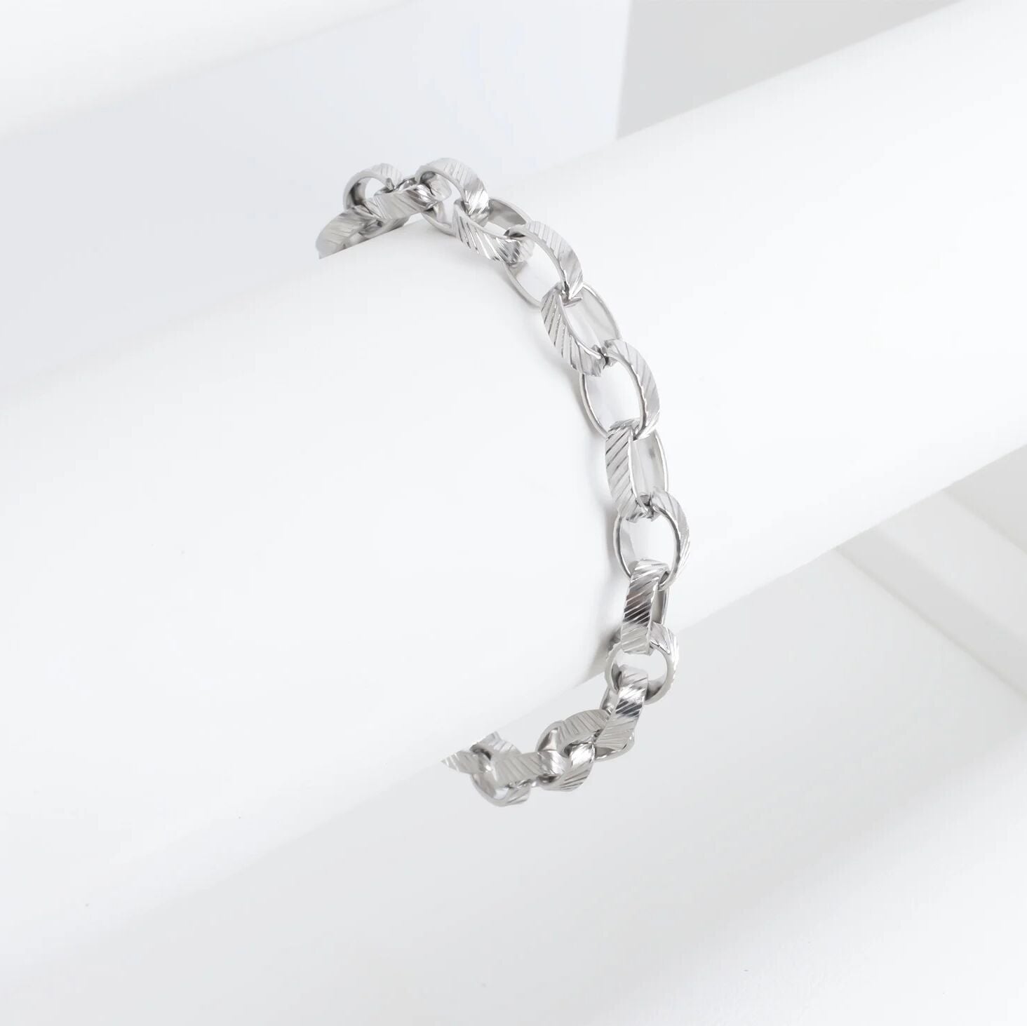 Silver chain bracelet on a light gray background