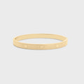 Gold bracelet on a light gray background