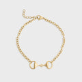 Gold bracelet with a horse bit design on a light gray background