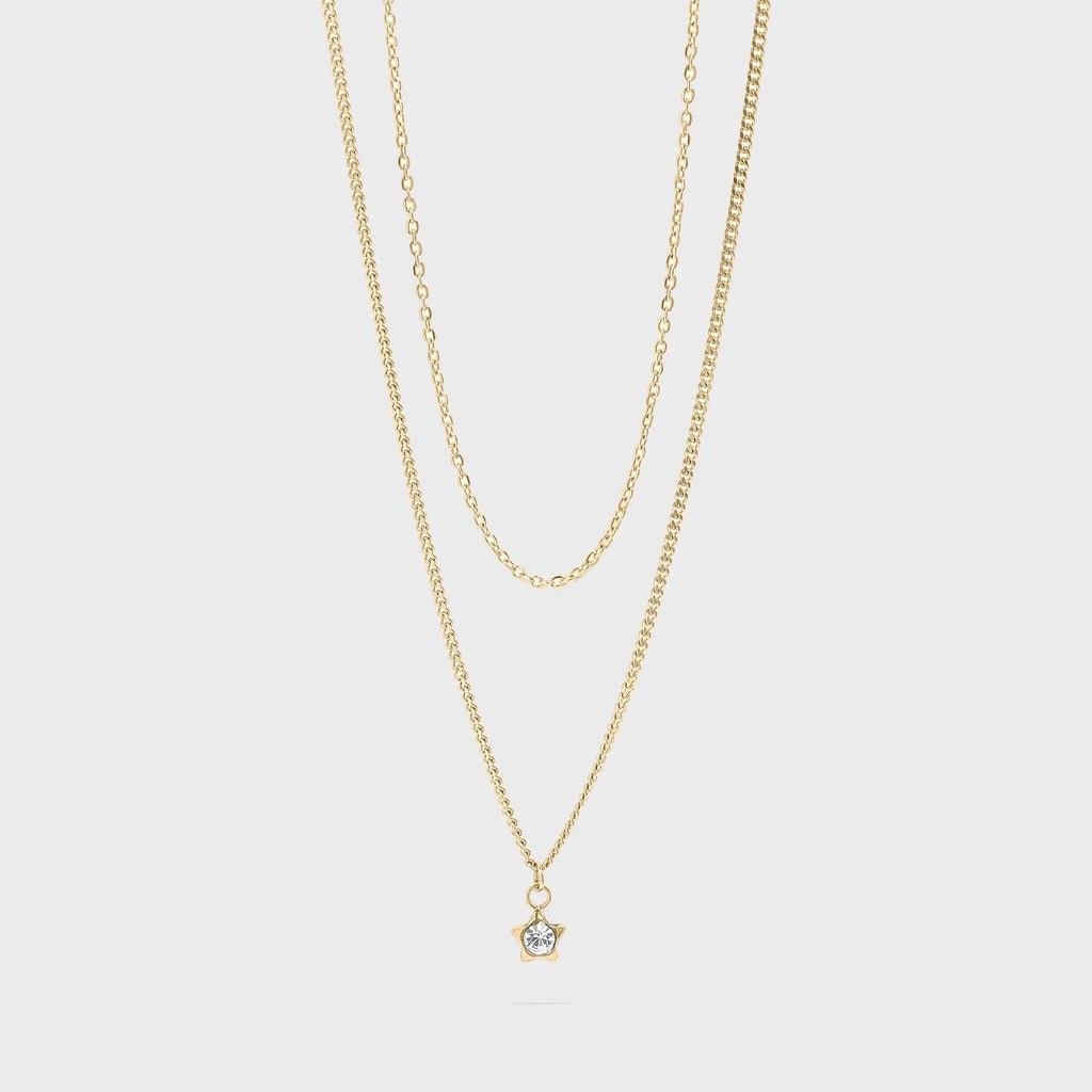 Gold necklace with a small star pendant on a light gray background