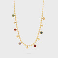 Gold necklace with colorful gemstones on a light gray background