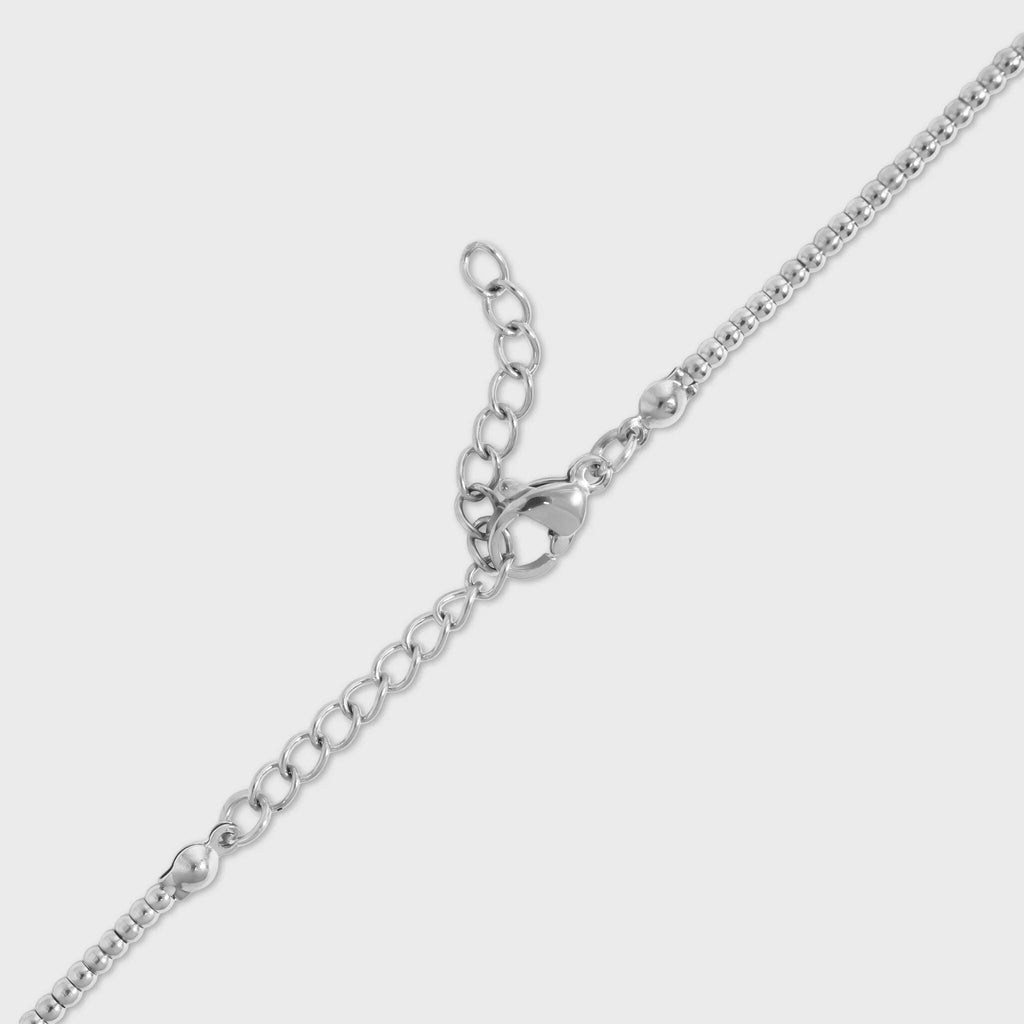 Silver lobster clasp for beaded chain necklace on a light gray background