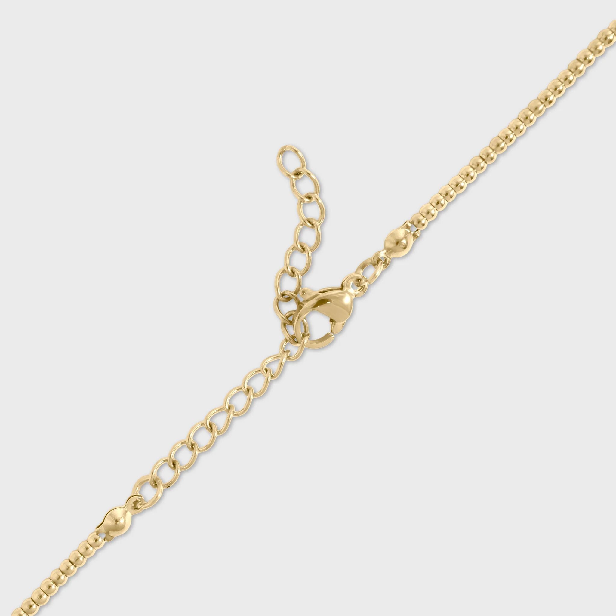 Gold lobster clasp for beaded chain necklace on a light gray background