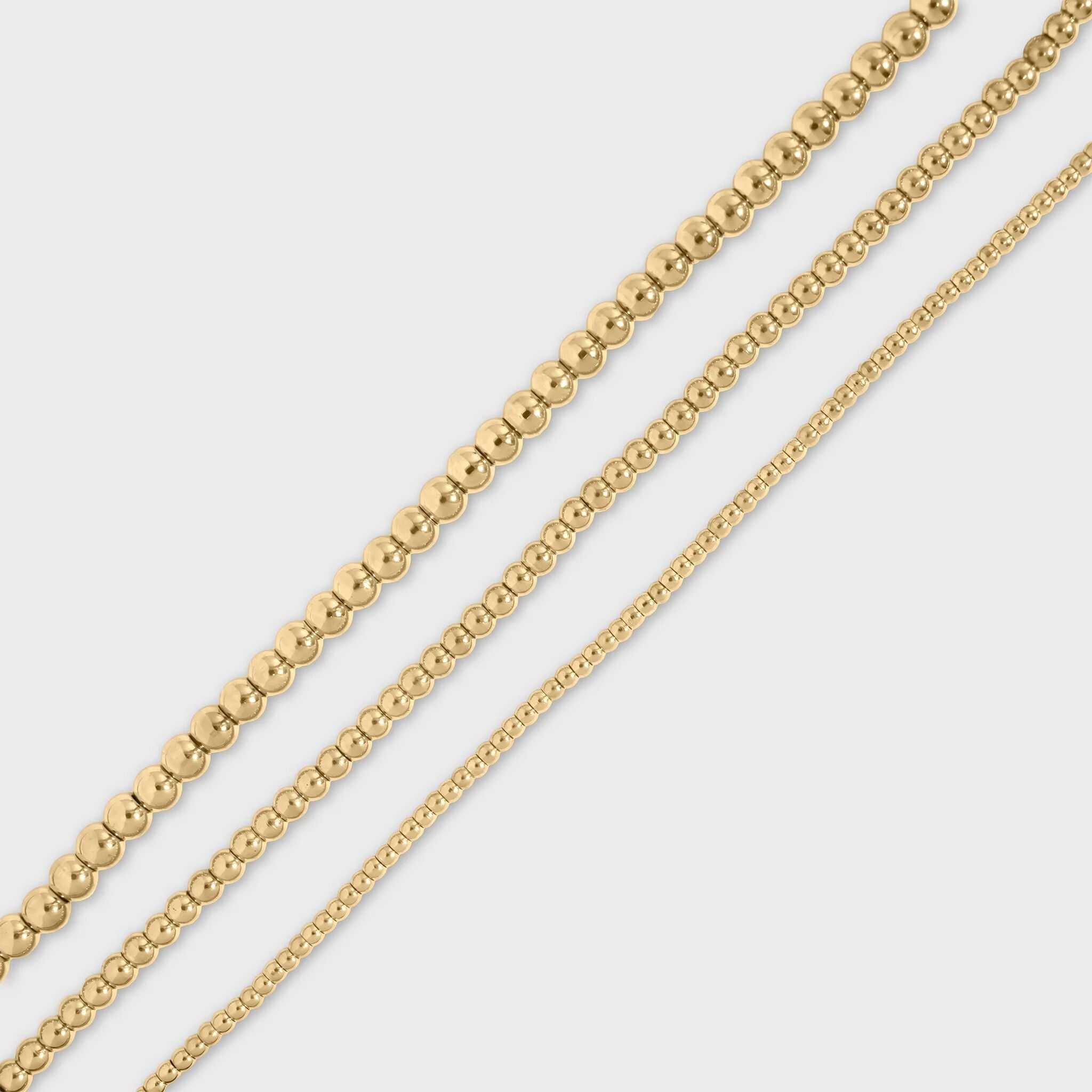 Gold beaded chain on a light gray background