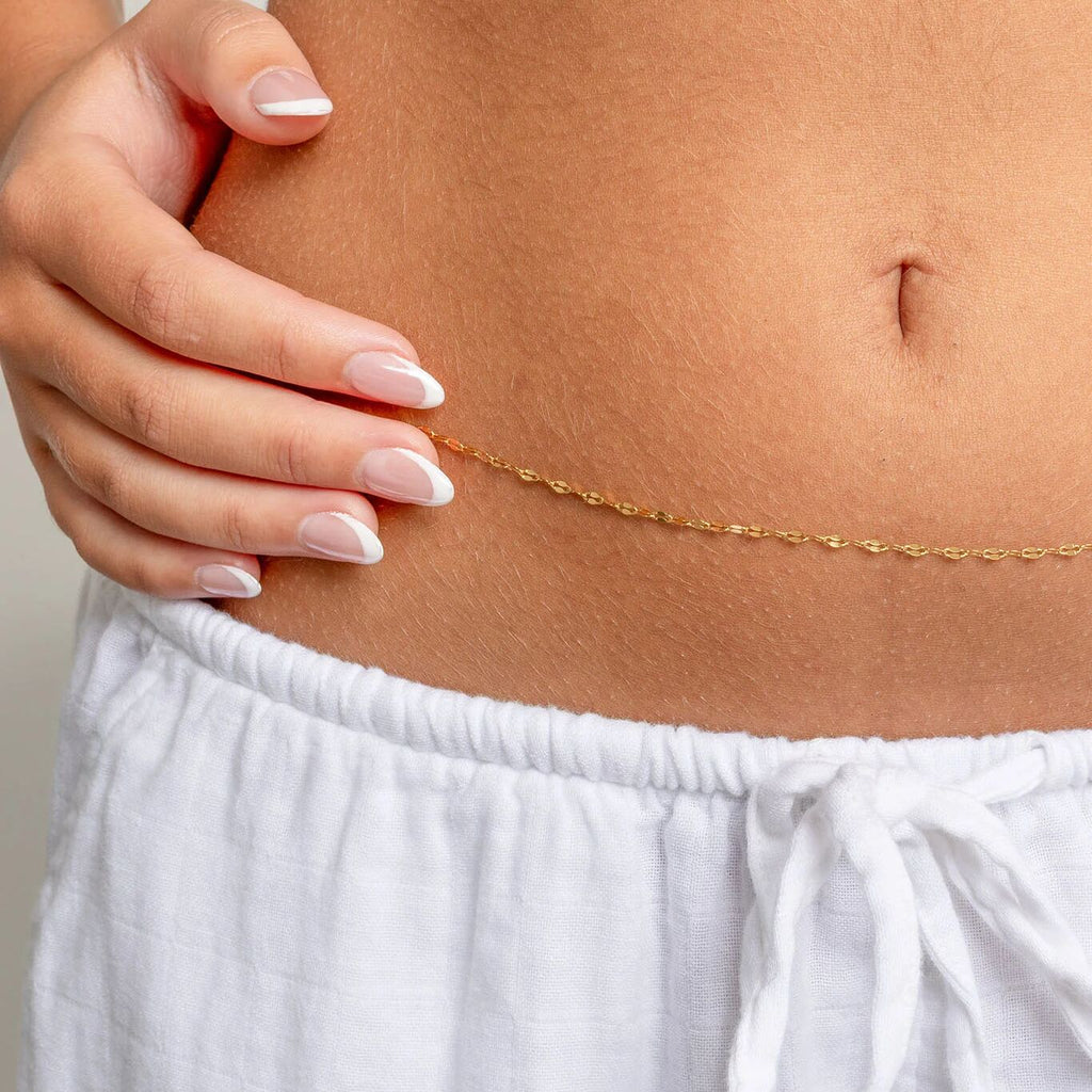 Gold Lip Belly Chain on a person's waist with a neutral background