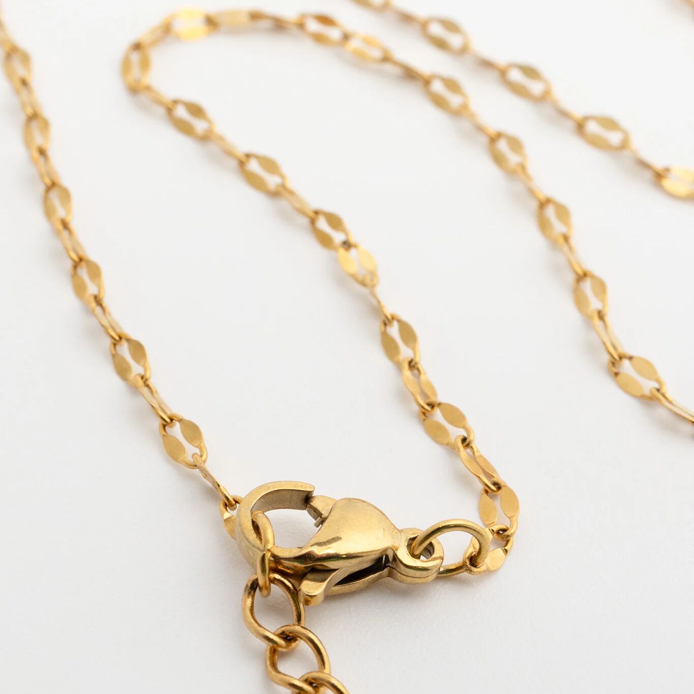 Gold Belly Lip Chain with clasp on a light gray background