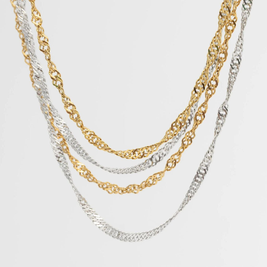 Two gold and silver Singapore Belly Chains on a light gray background