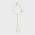 Gold hand chain on a light gray background
