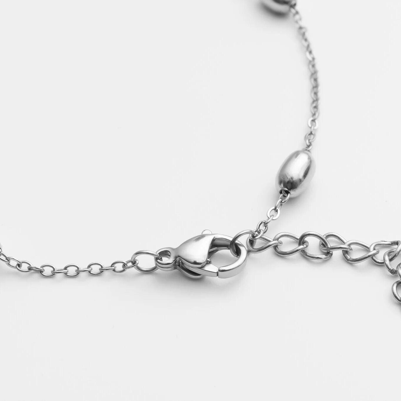 Close-up of a silver Statement Bead Hand Chain on a white background