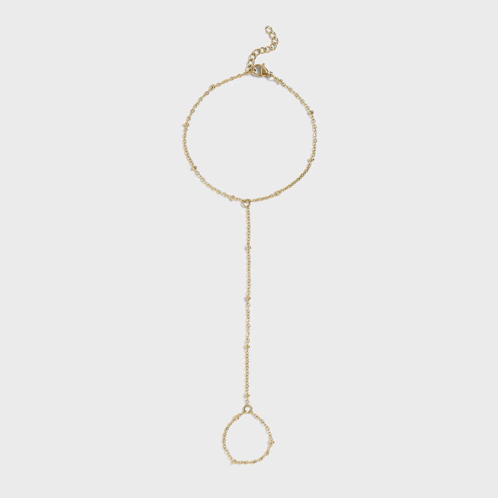 Gold hand chain on a light gray background