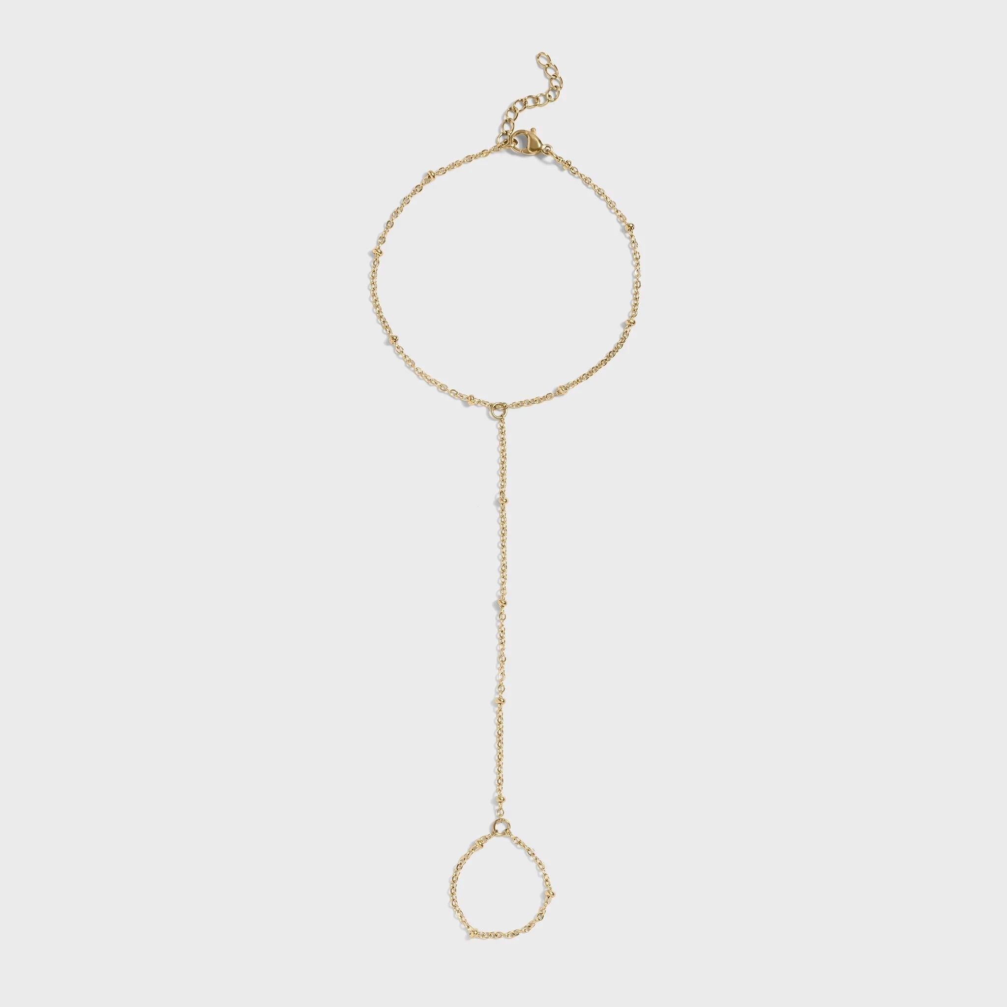 Gold hand chain on a light gray background