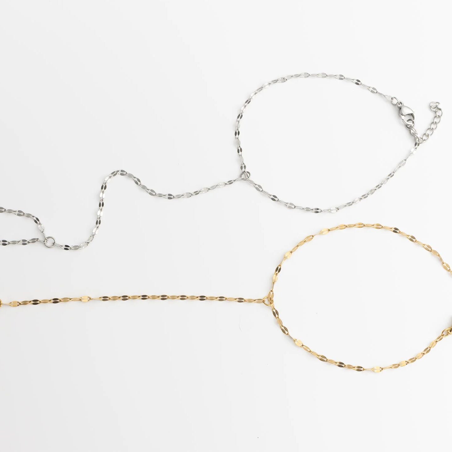 Two gold and silver Lip Hand Chains on a white background