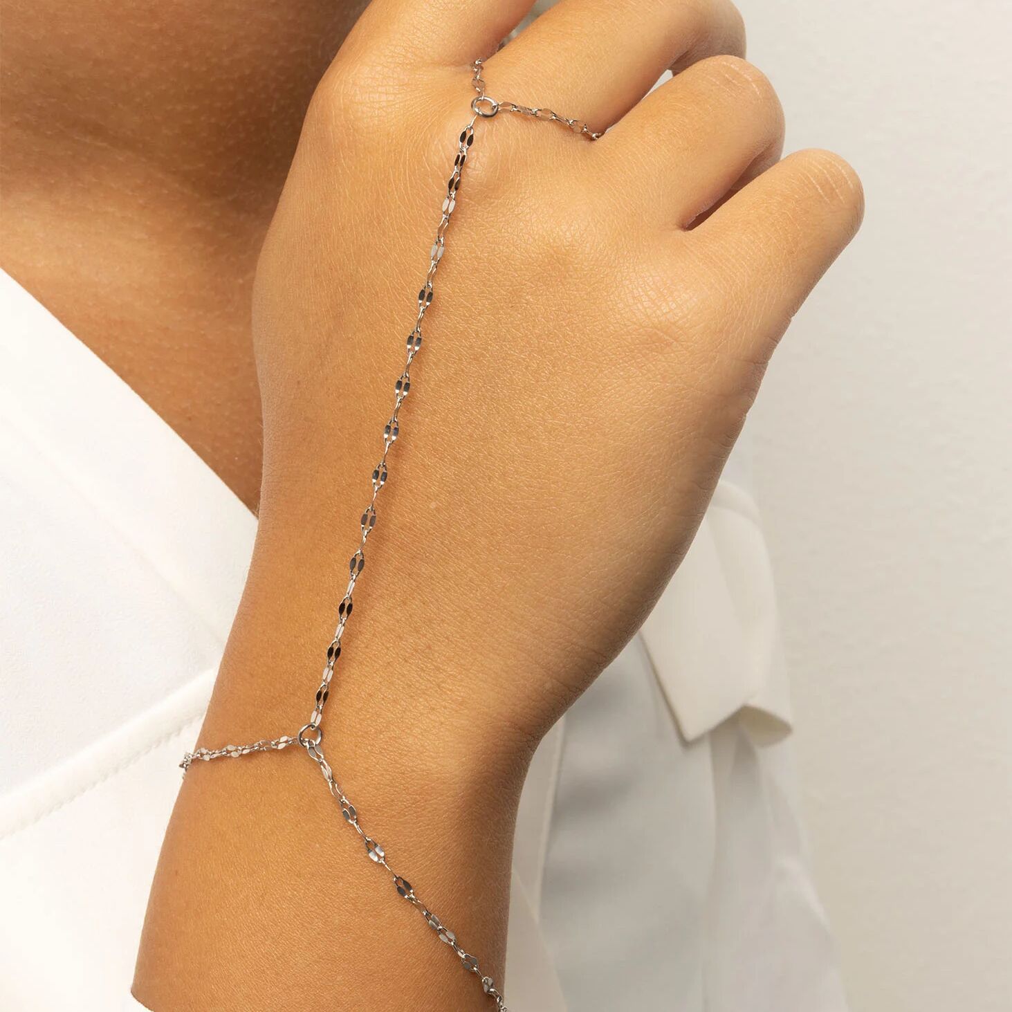 Silver Lip Hand Chain on a person's wrist with a plain background