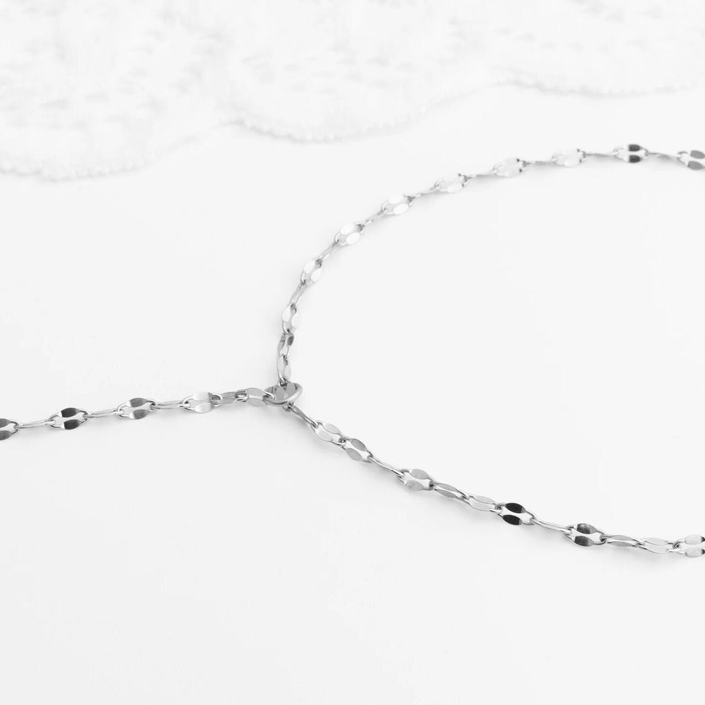 Close-up of a silver Lip Hand Chain on a white background