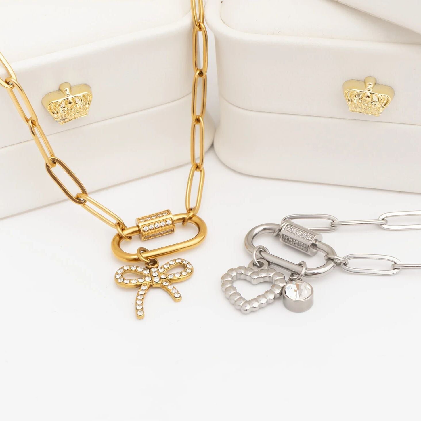 Gold and silver necklaces with charms on a white surface
