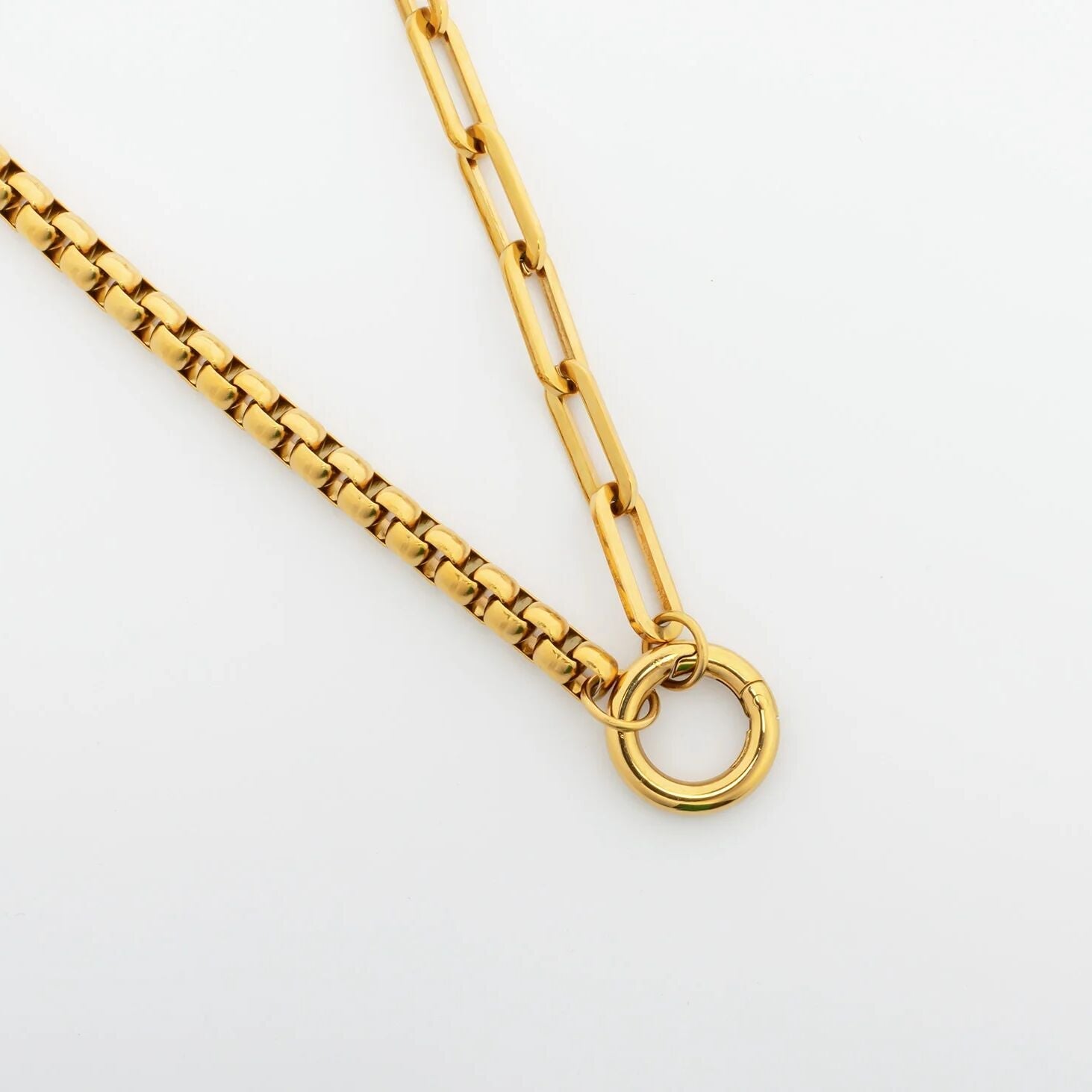 Gold chain necklace on a light gray background