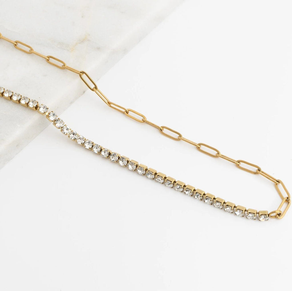 Gold chain necklace with embedded crystals on a white background