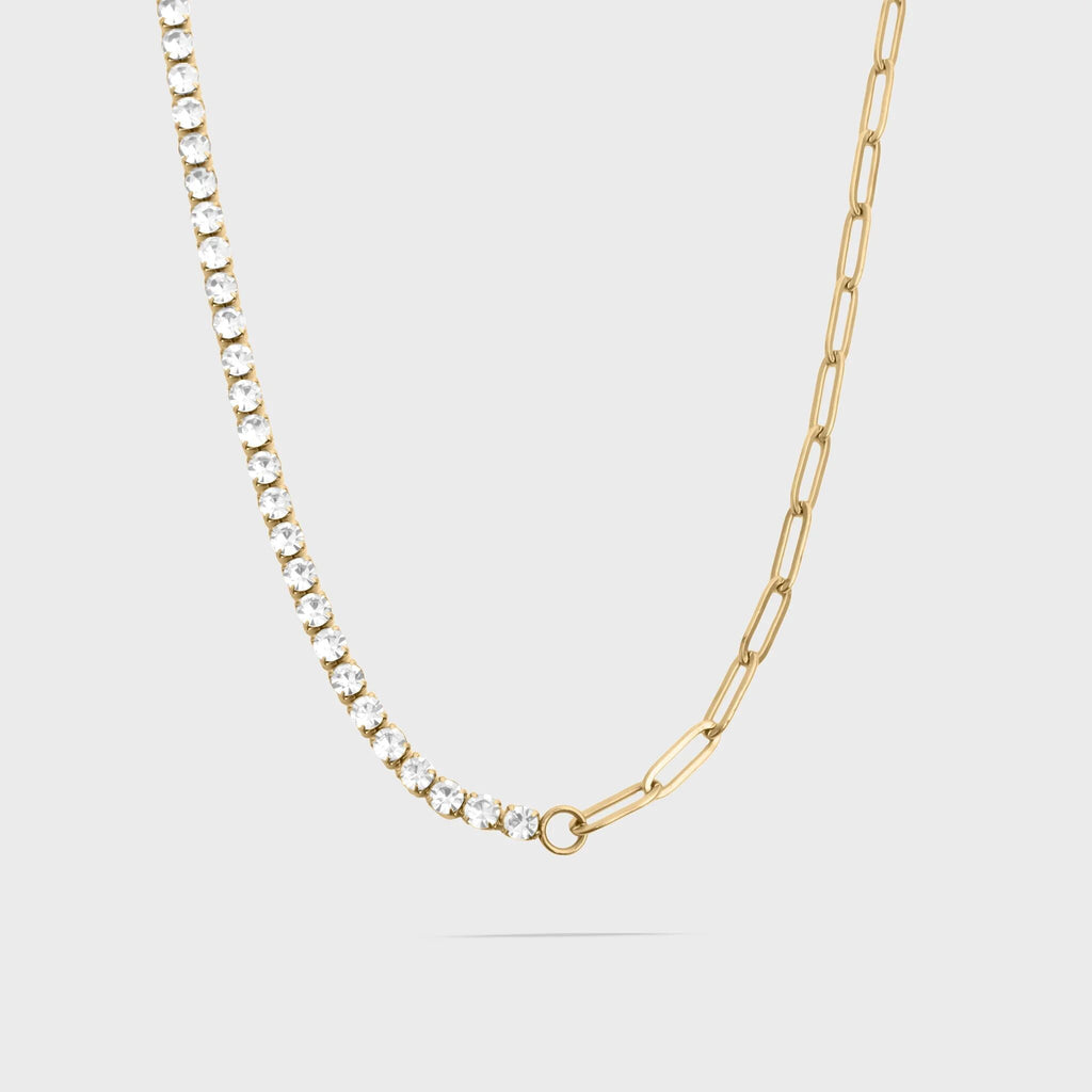 Gold chain necklace with small diamonds on a light gray background