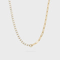 Gold chain necklace with small diamonds on a light gray background