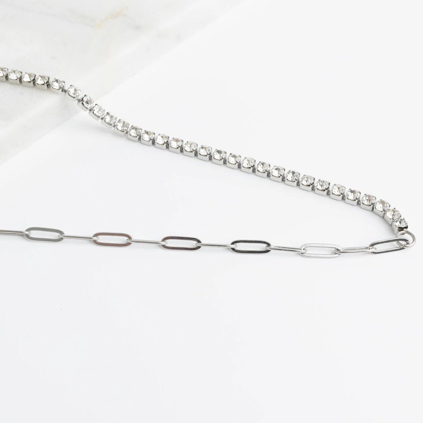 Silver chain necklace with small diamonds on a white background