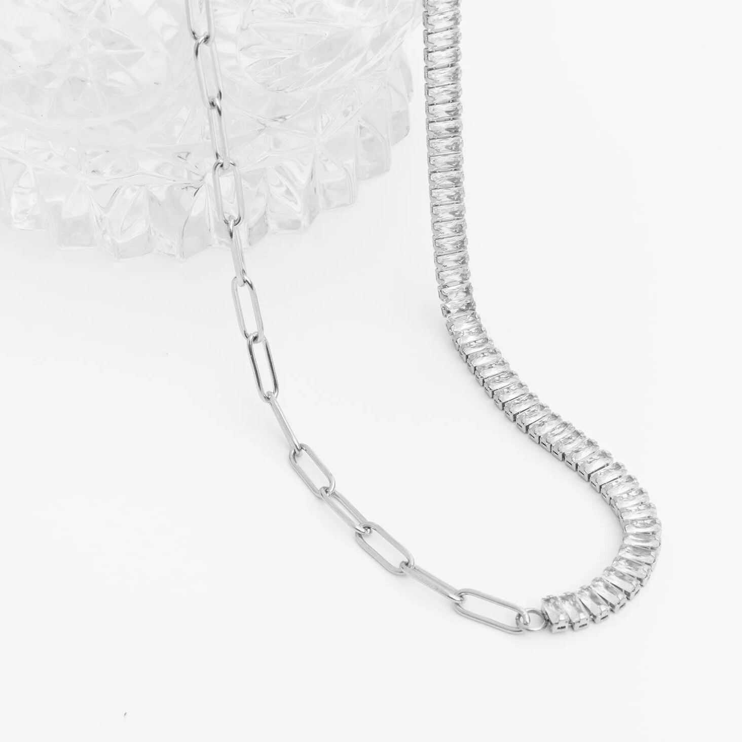 Silver chain necklace with diamond-like stones on a white background