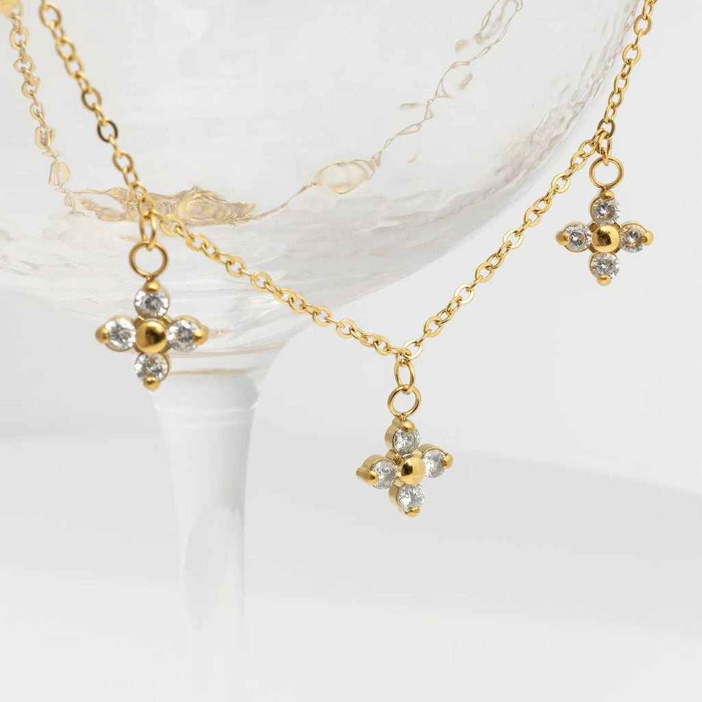 Gold necklace with floral pendants on a white background