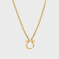 Gold necklace with a horse shoe clasp on a light gray background