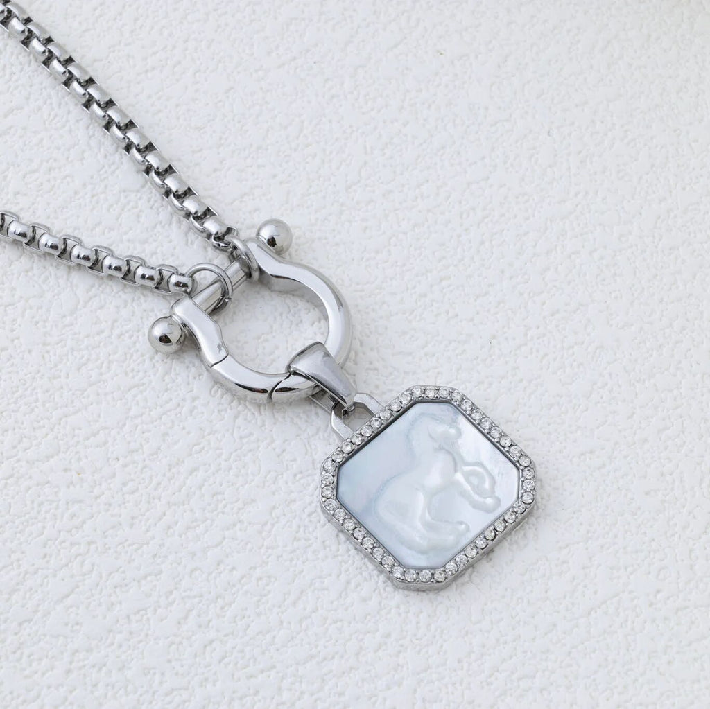 Silver necklace with a pendant on a light gray background