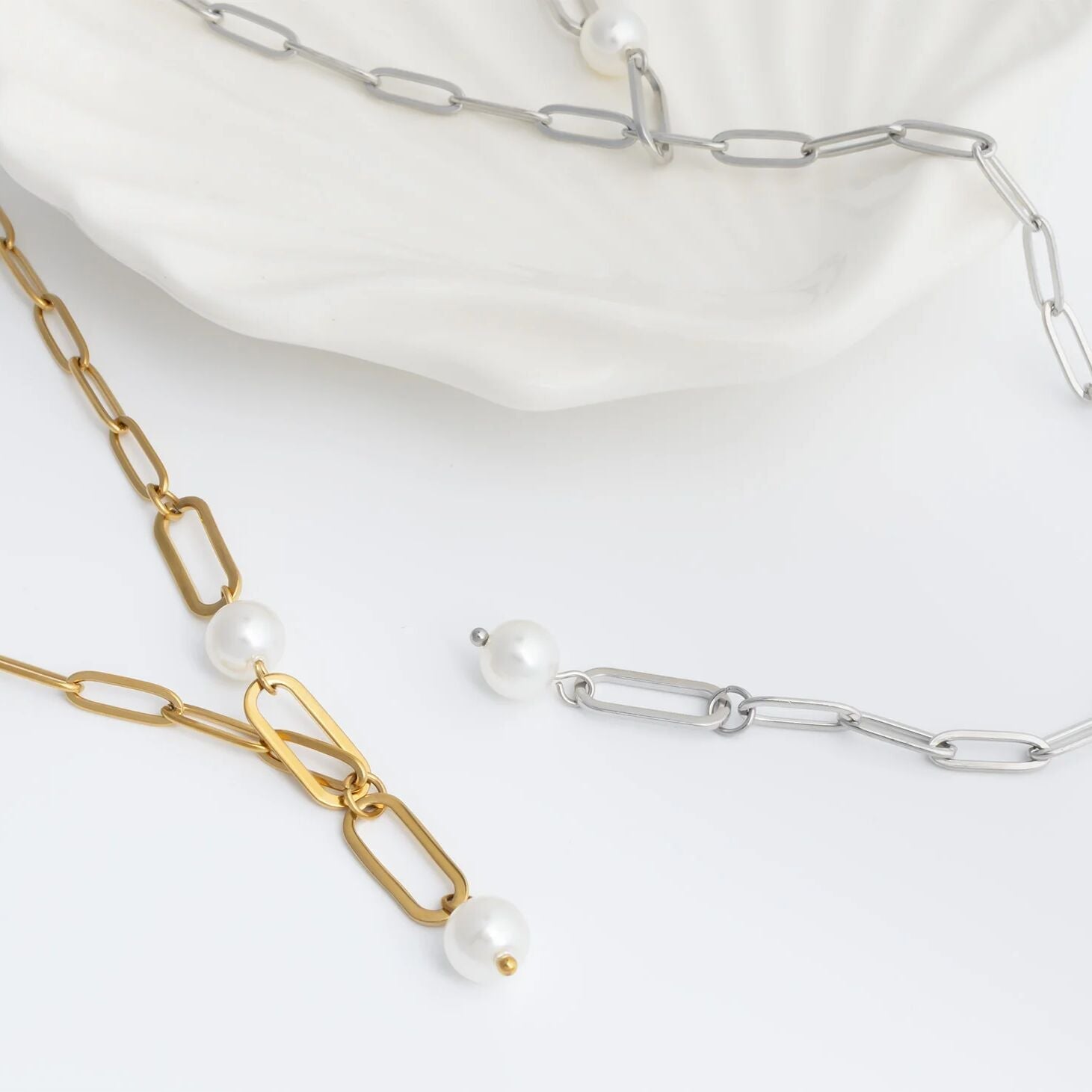 Gold and silver y-shaped chain necklaces with two pearls on a white background