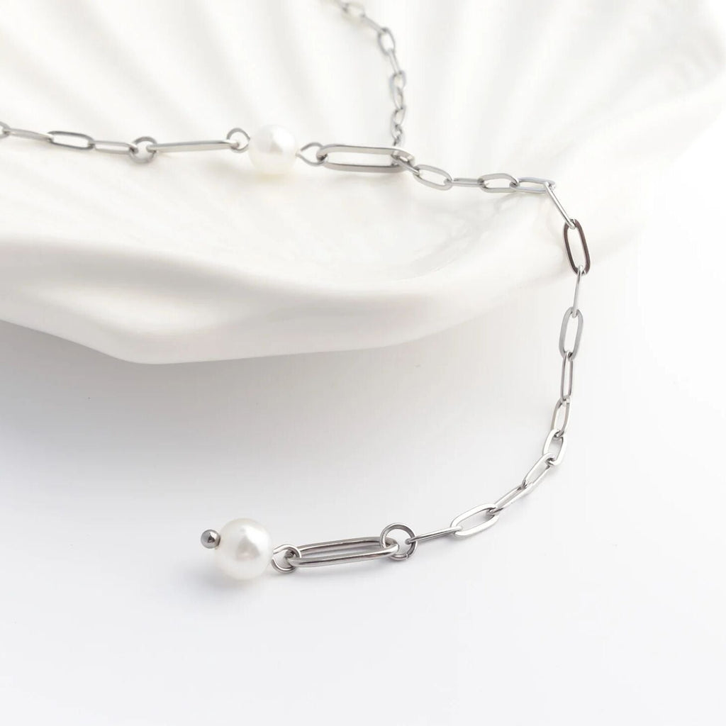 Silver chain necklace with pearls on a white background