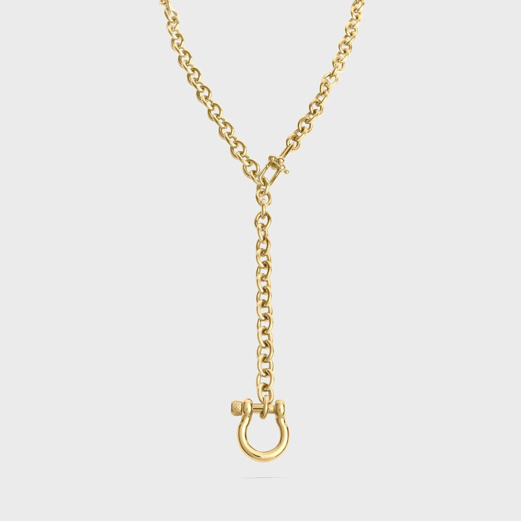 Gold necklace with a clasp on a light gray background
