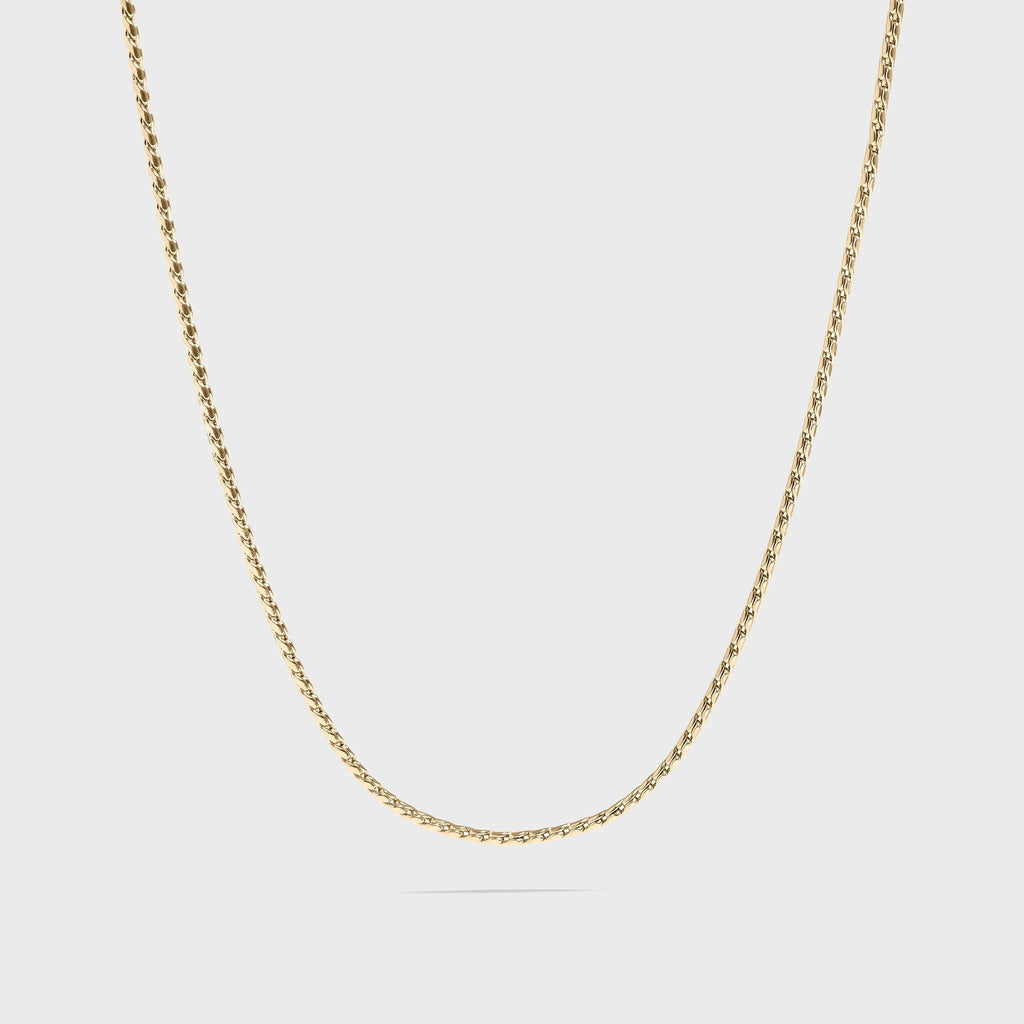 Gold chain necklace on a light gray background