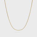 Gold chain necklace on a light gray background