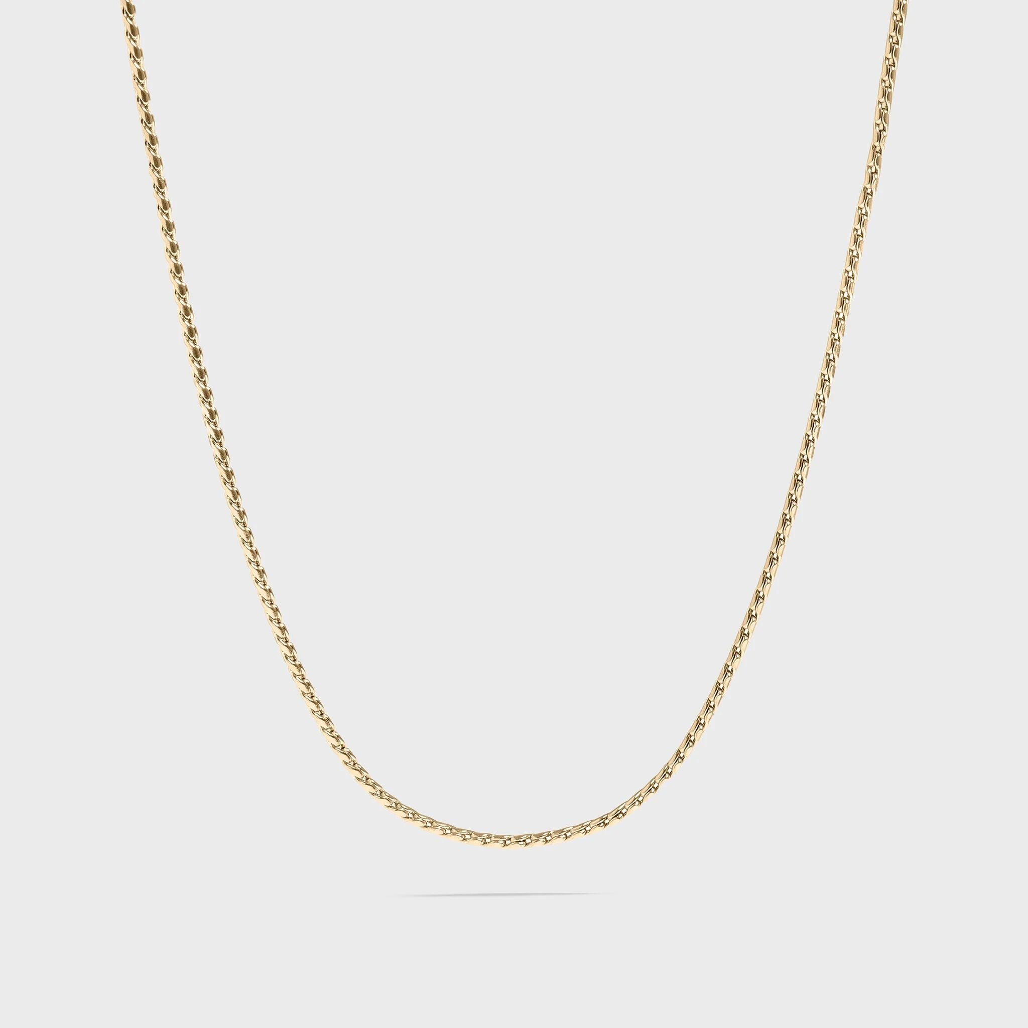Gold chain necklace on a light gray background