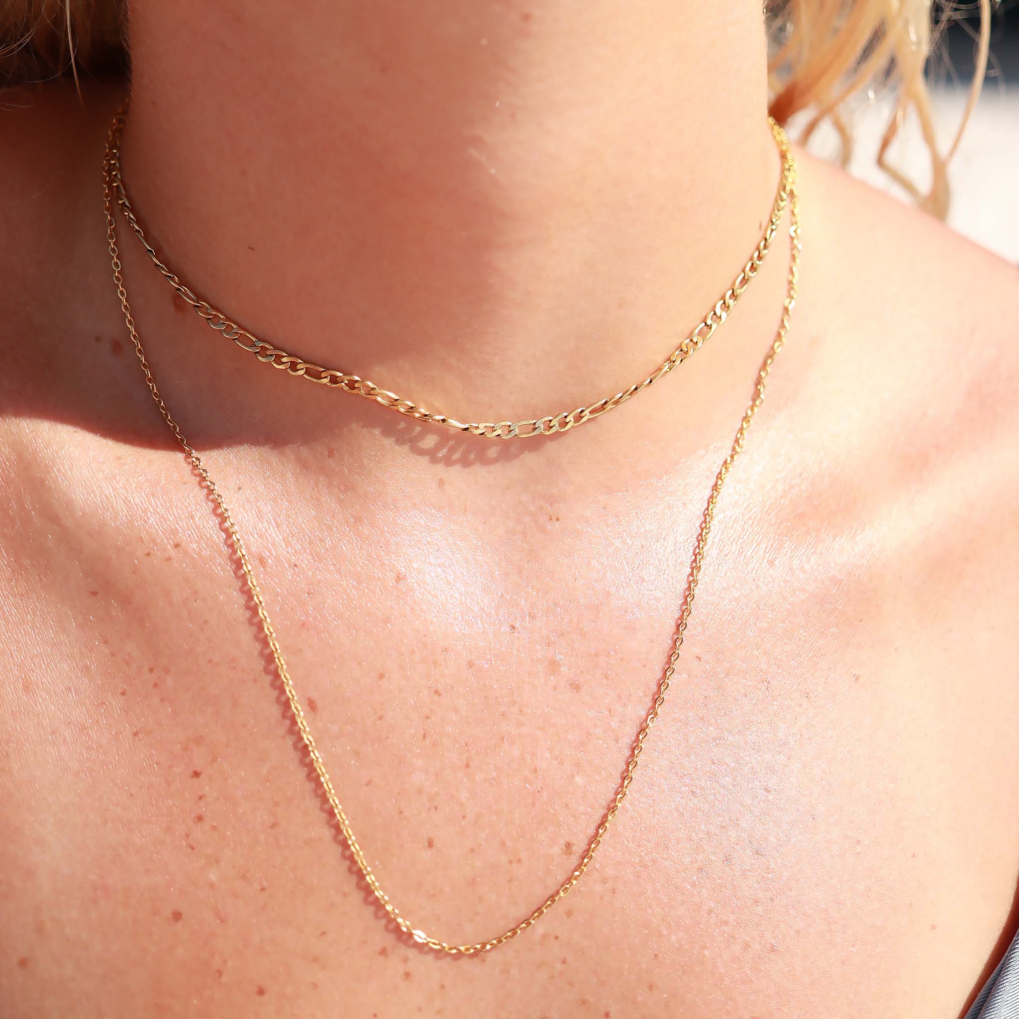 Close-up of a gold chain necklace on a person's neck
