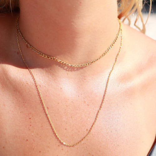 Close-up of a gold chain necklace on a person's neck