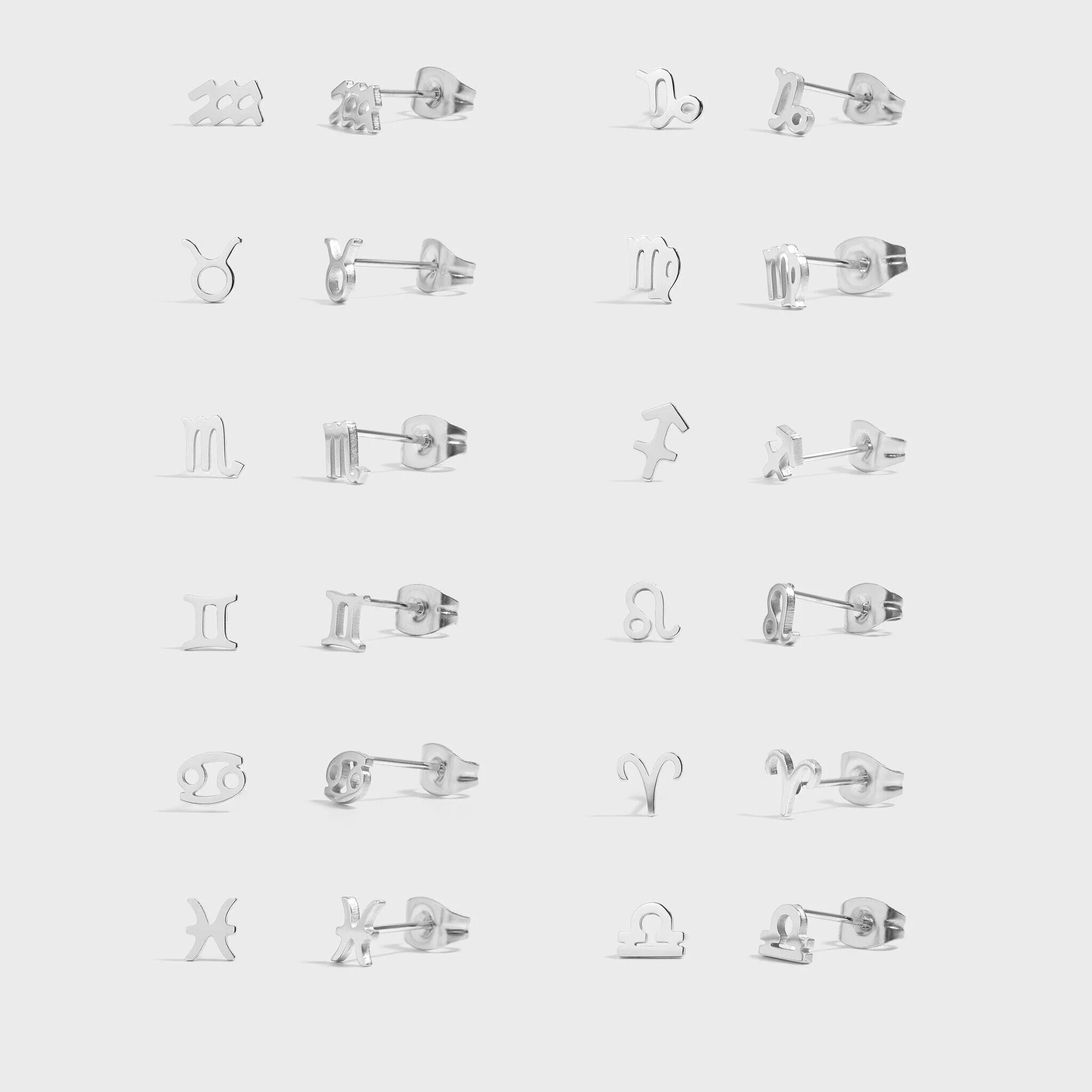 Collection of silver zodiac sign earrings on a white background