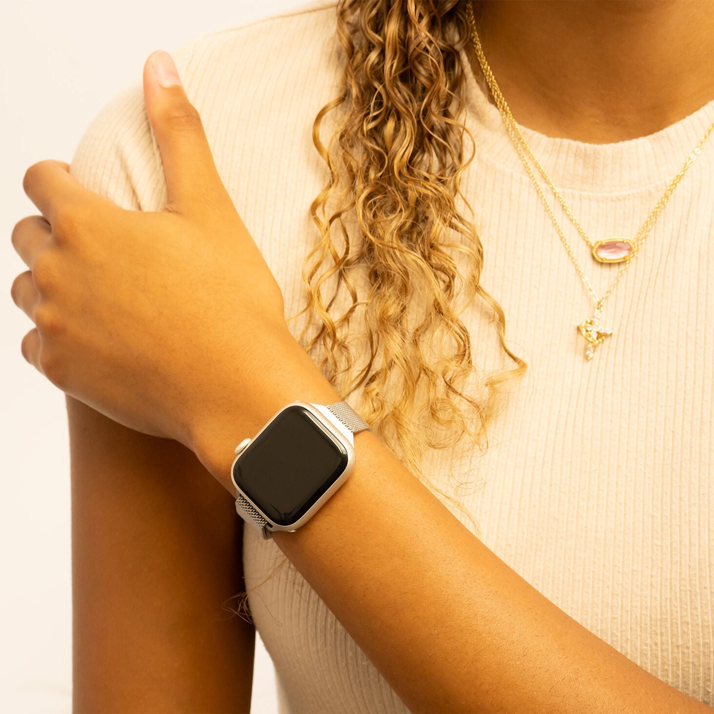 Person wearing a smartwatch with a plain background