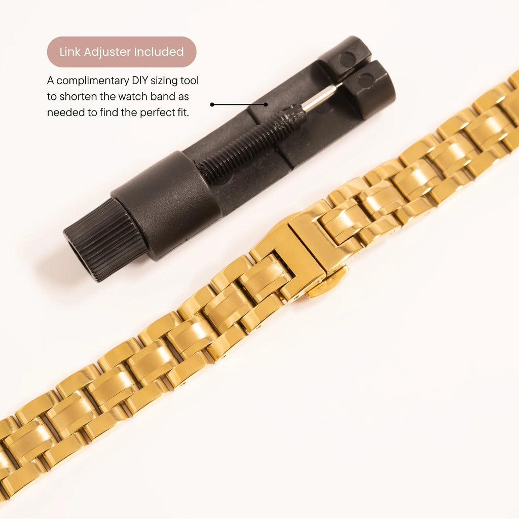 Gold watch band with black link adjuster on a white background