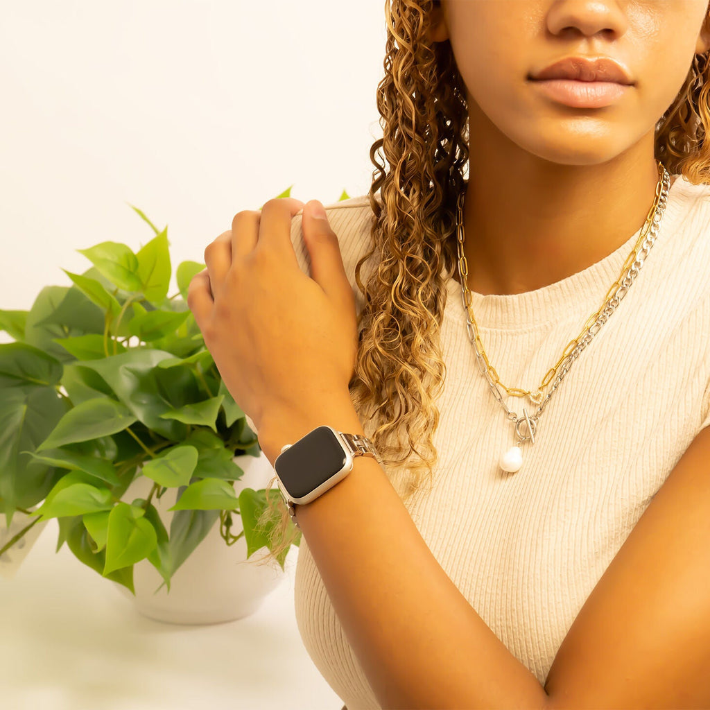 Woman wearing a smartwatch with a plant in the background
