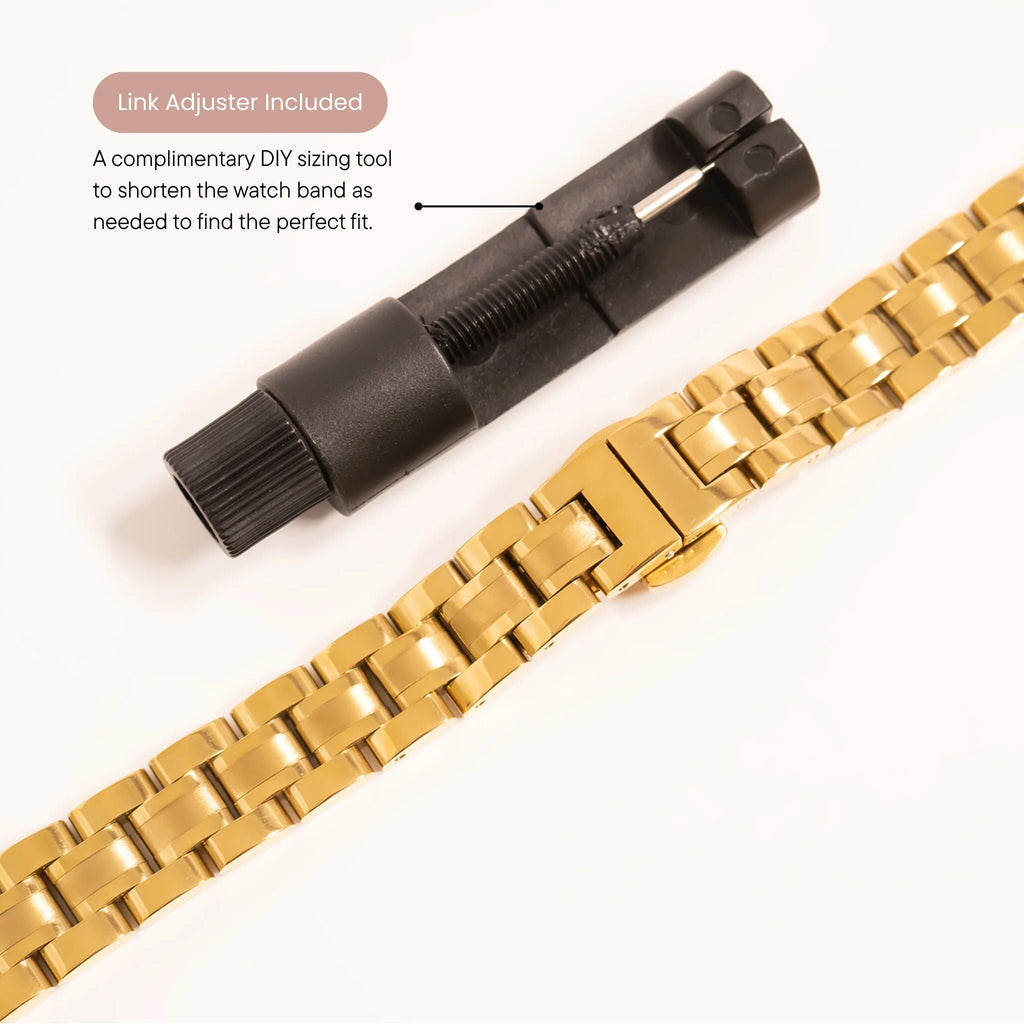 Gold watch band with black link adjuster on a white background