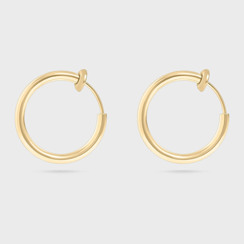 Gold hoop earrings on a light gray background