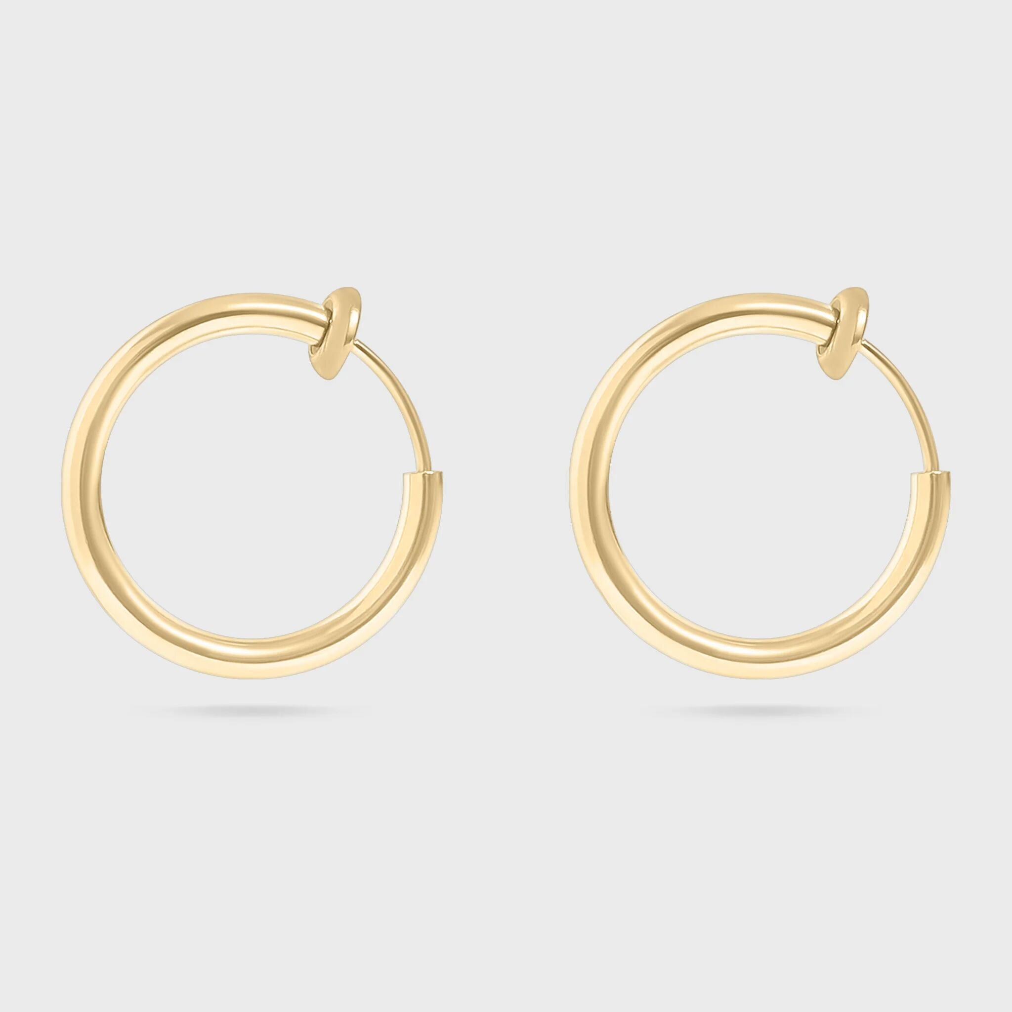 Gold hoop earrings on a light gray background