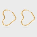 Heart Shaped gold hoop earrings on a light gray background