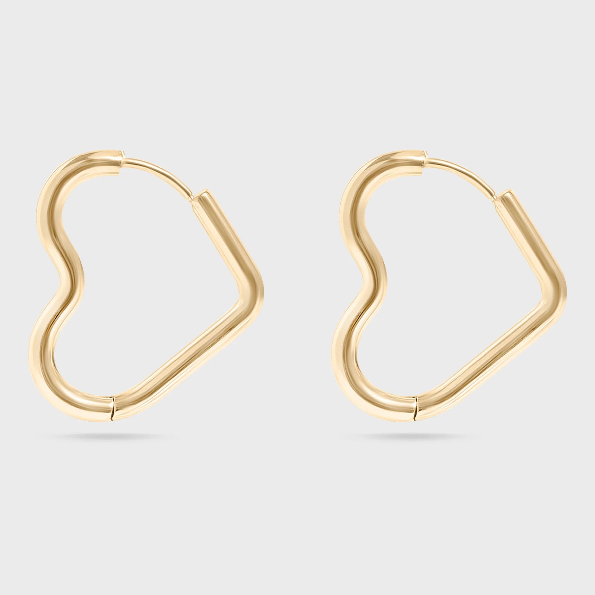 Heart Shaped gold hoop earrings on a light gray background