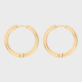 Gold hoop earrings on a light gray background