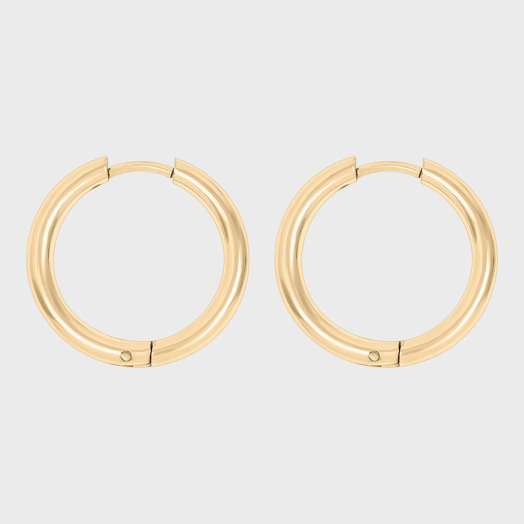 Gold hoop earrings on a light gray background