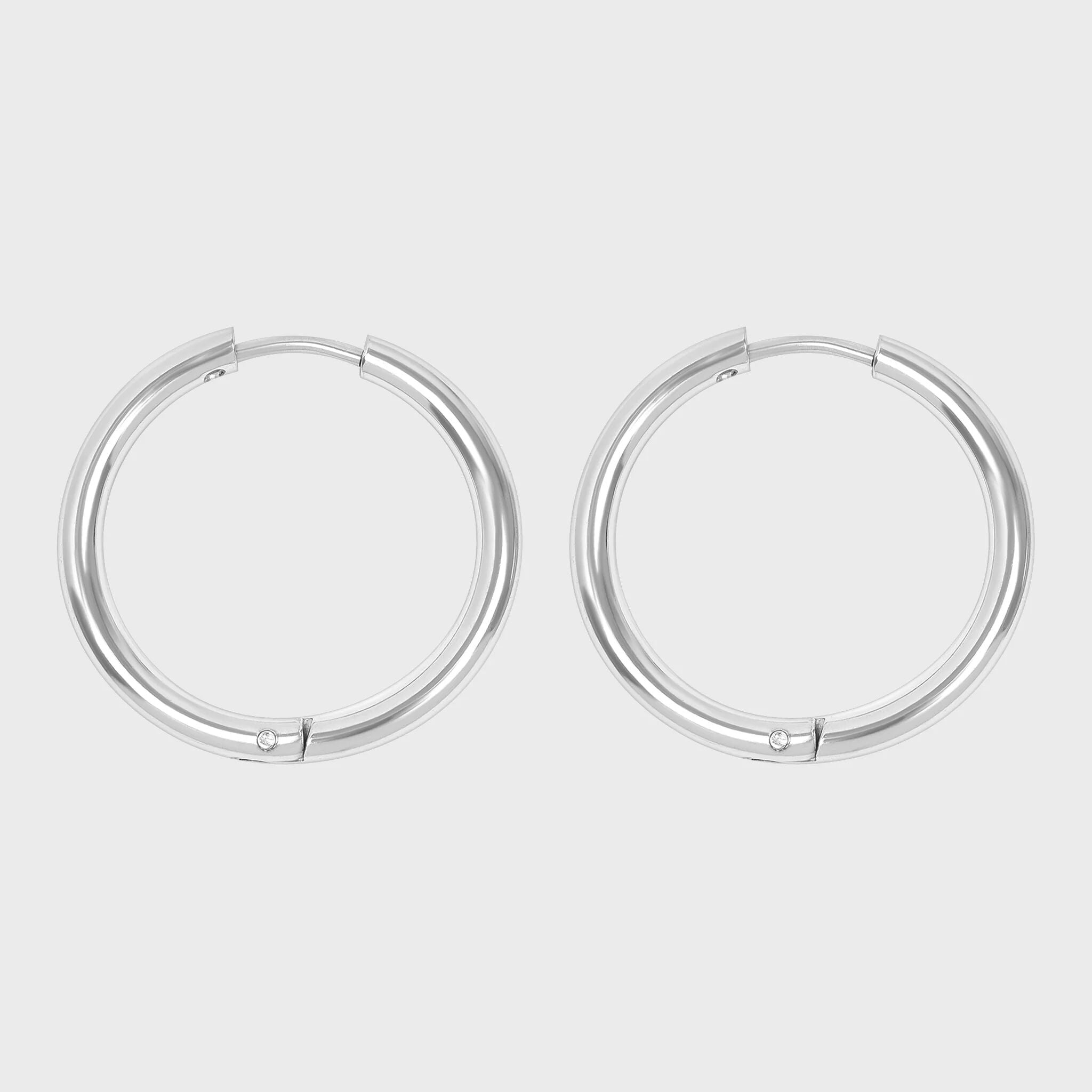Pair of silver hoop earrings on a light gray background